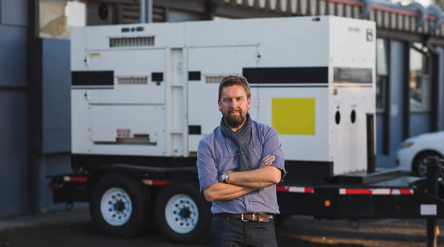 Facilities manager standing in front of generator